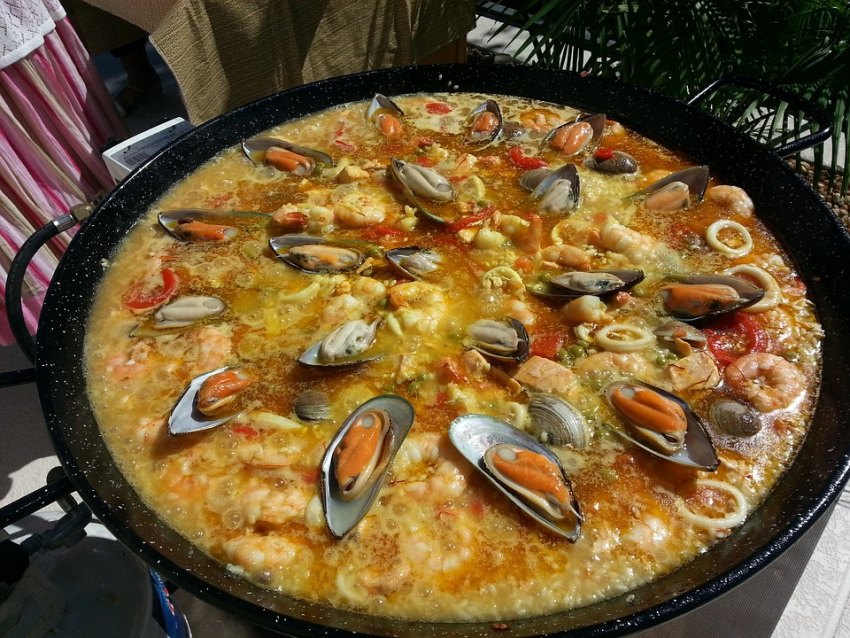 valencian paella με ρύζι, αυθεντικό πιάτο στο μεγάλο τηγάνι χωρίς αρακά αλλά με καλαμάρια